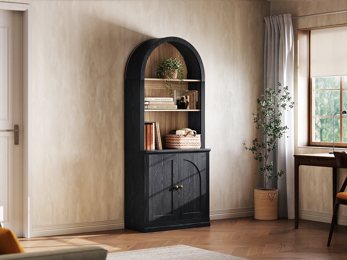 Monos black tall arch-top cabinet displayed beside a window with books and decor