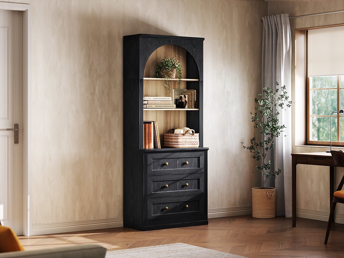 Monos black tall drawer cabinet displayed beside a window with books and decor
