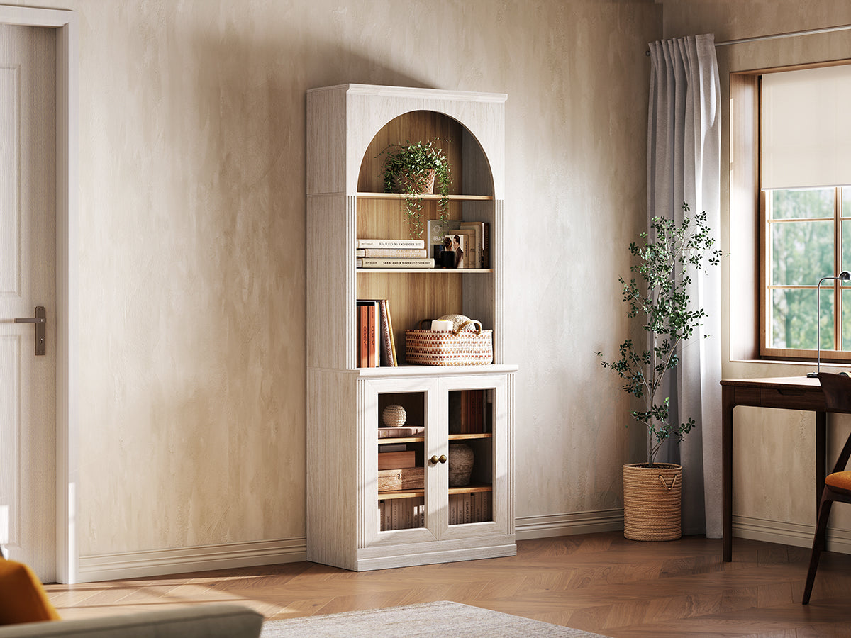 Monos white tall display cabinet shown beside a window with books and decor inside