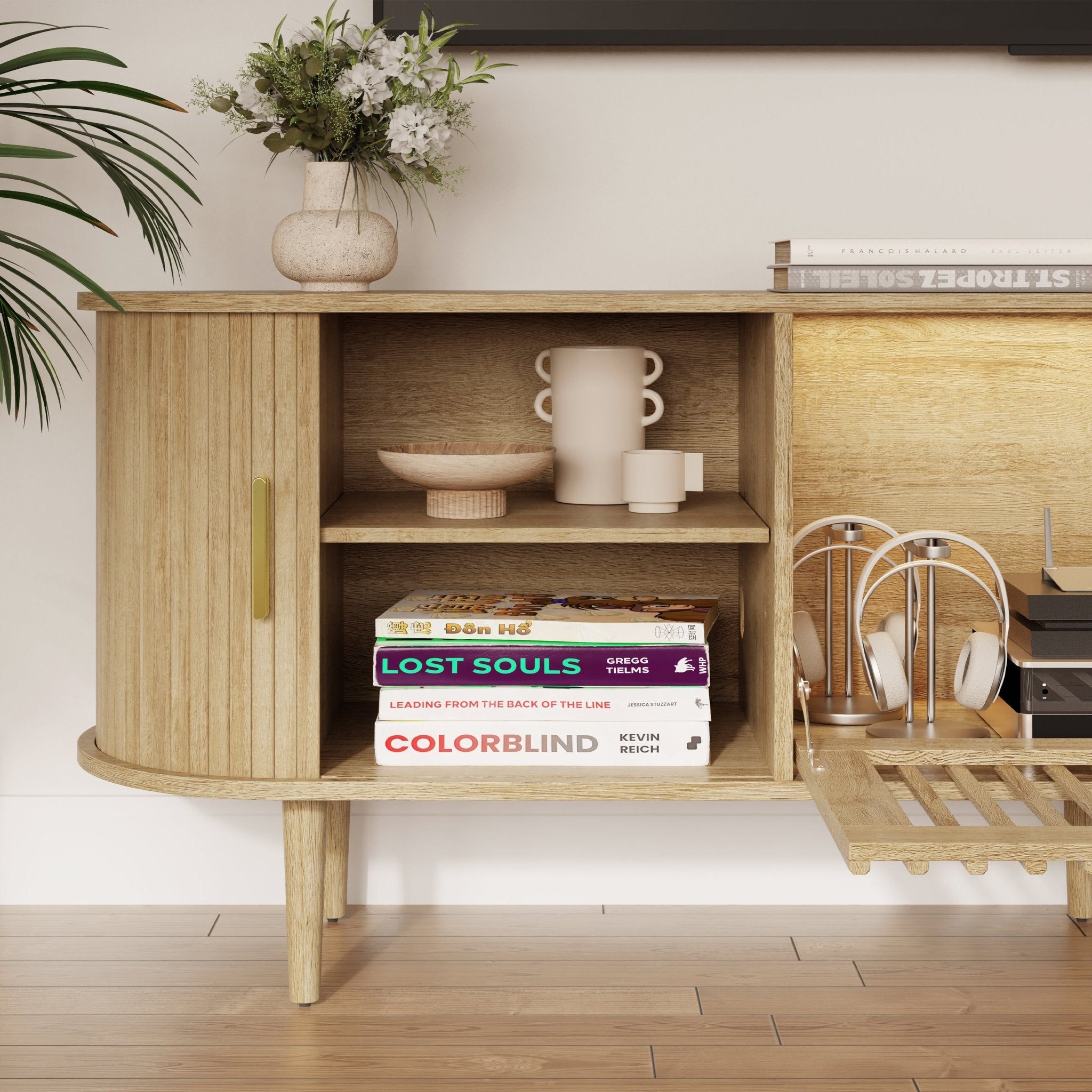 Light wood fluted storage cabinet with open shelving, books, and decor in a living room